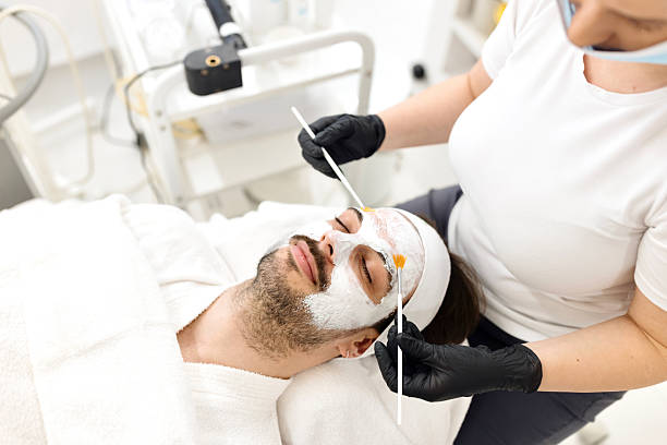 istock Cosmetologist applying a cosmetic peeling mask to a client's face. 2247176948