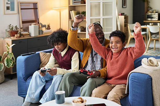 istock Mature Black Man Playing Video Games with Two Happy Black Boys 2247177511