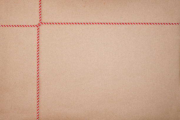 Red and White Christmas String Cross Tied on Kraft Paper Background