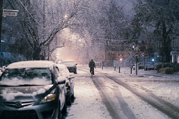 Late at night on November 10th, a man is riding his bicycle during the first heavy snowfall of the year.