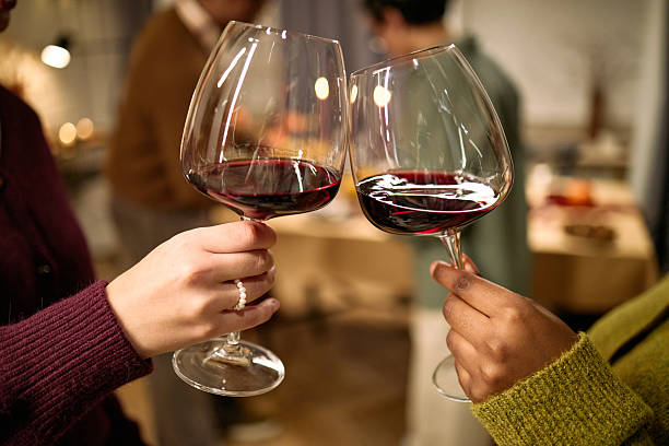istock Female Friends Clinking Wine Glasses Celebrating Thanksgiving 2247181212