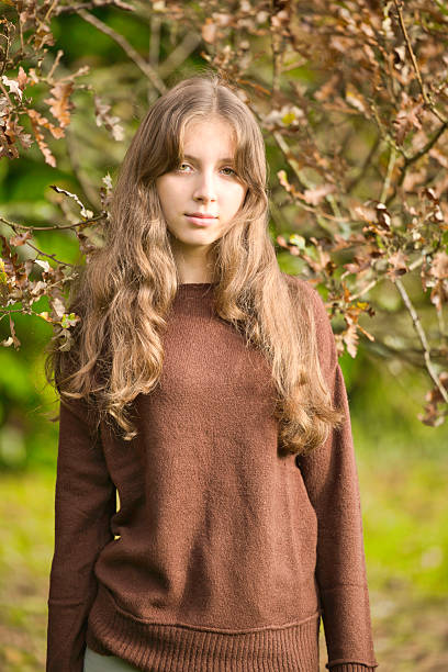 Sixteen year old girl wearing green and brown by an old oak tree.
