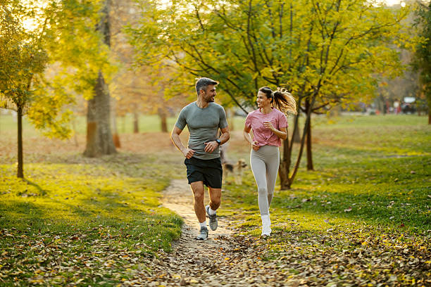 istock Couple jogging in park during autumn season 2247182471