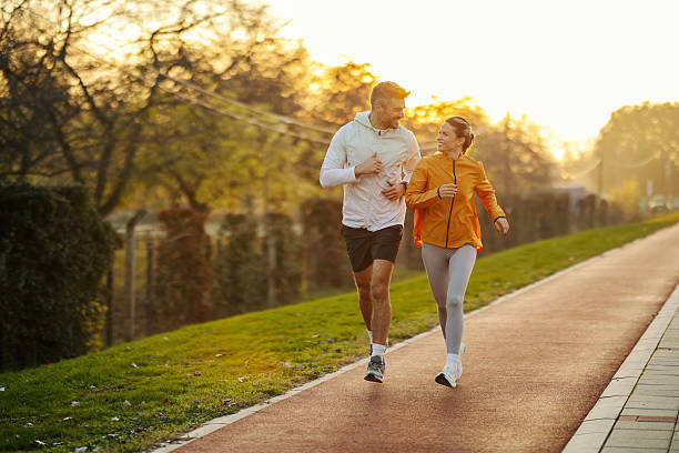 istock Couple jogging enjoying morning run through park 2247183046
