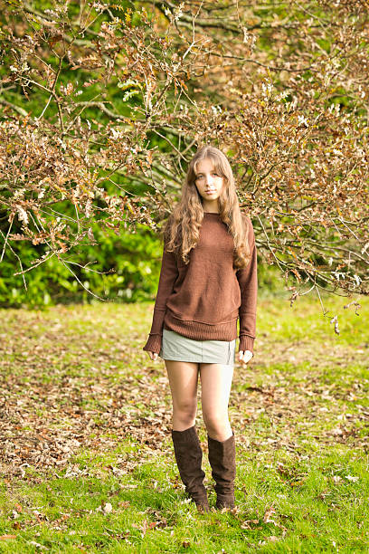 Sixteen year old girl wearing green and brown by an old oak tree.