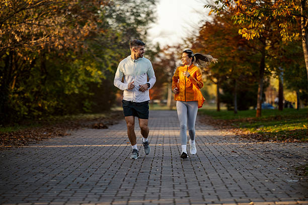 istock Couple jogging in park during autumn afternoon 2247183121