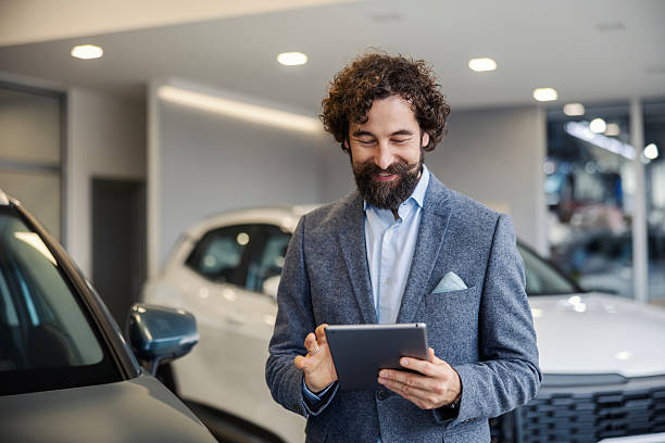 istock Car salesman using a tablet in showroom 2247183419
