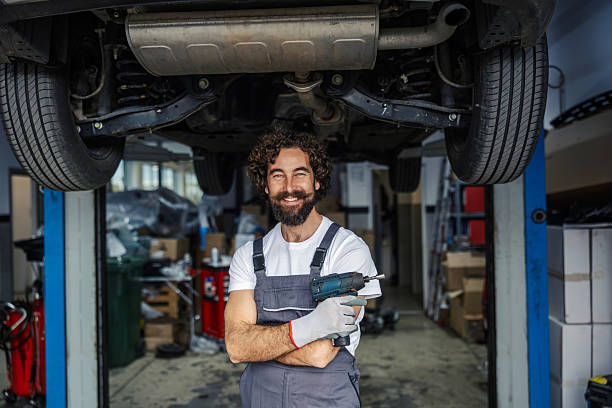 istock Mechanic smiling holding power tool in car service 2247184203