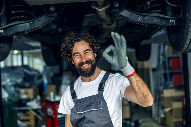 istock Happy mechanic giving okay sign under a car 2247184205