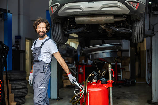 istock Friendly mechanic standing next to car during oil change 2247184314
