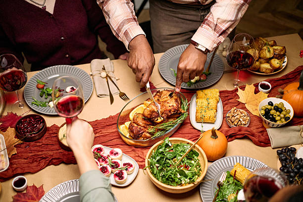 istock Hands of Diverse Guests Carving Roast Turkey during Thanksgiving Celebration 2247185059