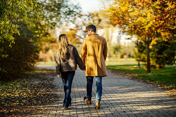 istock Romantic couple walking holding hands in autumn park 2247186300