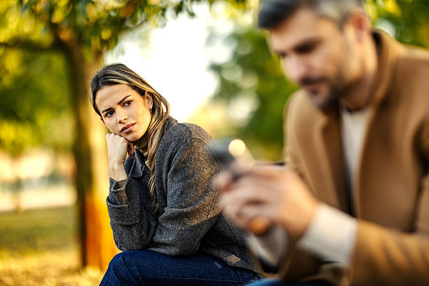 istock Upset woman watching man ignoring her using smartphone 2247186544