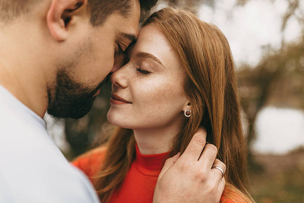 istock intimate scene capturing affectionate forehead kiss with soft hair and autumnal background 2247186636