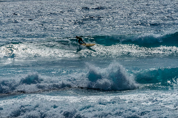 Colorful Surfer Offshore Ship Island Waves Sandy Beach Southeastern Oahu Hawaii. Famouse Surfing beach with Large Shore Break .