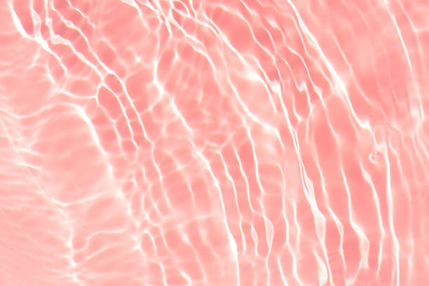 istock Pink water bubbles on the surface ripples. Defocus blurred transparent pink colored clear calm water surface texture with splash and bubbles. Water waves with shining pattern texture background 2247188963