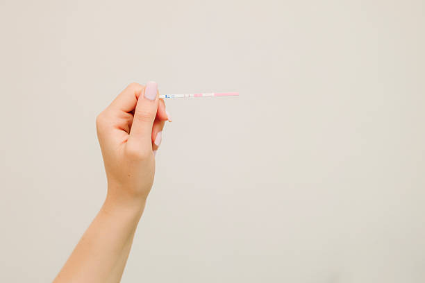 istock Future mother holds positive pregnancy test with positive result on white background. 2247192342
