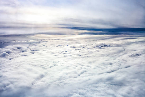 Stratiform clouds. Expansive aerial view of fluffy white blanket cloud stretching across sky, bathed in soft light. Themes of freedom, travel, dreams, tranquility. Evokes sense of peace, vastness