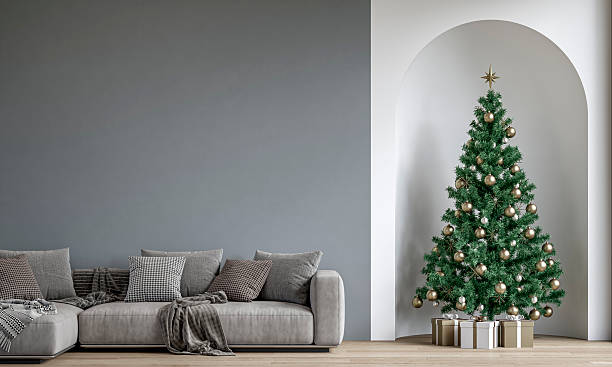 istock Modern minimalist interior decorated for Christmas, with sofa in front of gray plaster wall, a Christmas tree with presents in a wall niche, near a window 2247197309