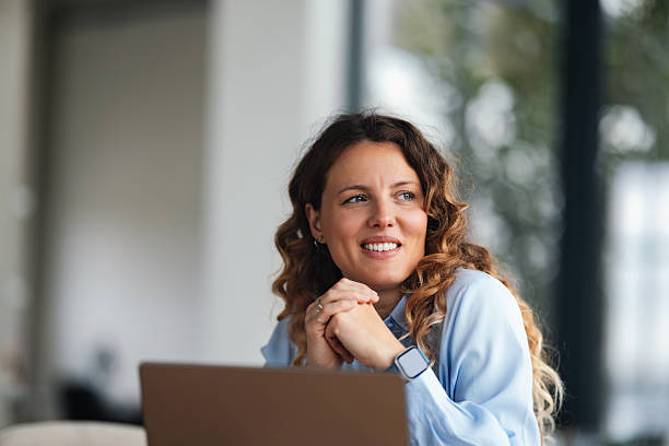 istock Confident Businesswoman Smiling While Working in a Modern Office With Laptop 2247197644