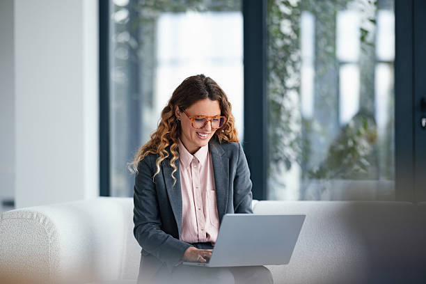 istock Professional Woman Working On Laptop In Modern Office Lounge Setting For Stock 2247197822