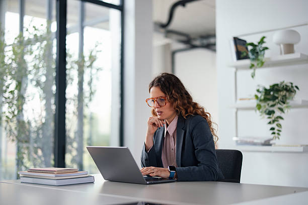 istock Professional Woman Working At Laptop In Modern Office Setting For Stock Listing 2247197847