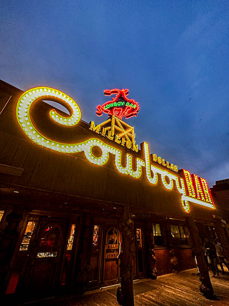 Jackson, Wyoming, USA - October 10, 2023 - Illuminated sign of the Million Dollar Cowboy Bar in Jackson, Wyoming. Large cursive 