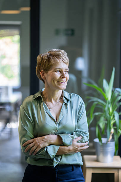istock Smiling businesswoman with folded arms in modern office 2247202731