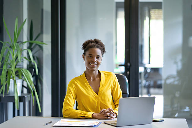 istock Young smiling businesswoman working at her desk in a modern office 2247202736