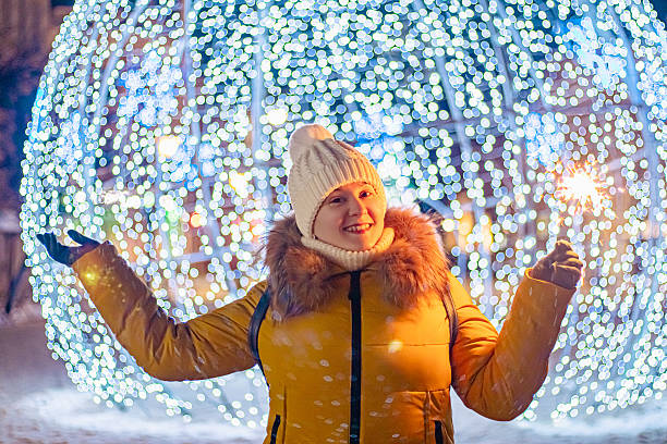 istock Young woman in knitted hat holds sparkler in her hands. 2247204276