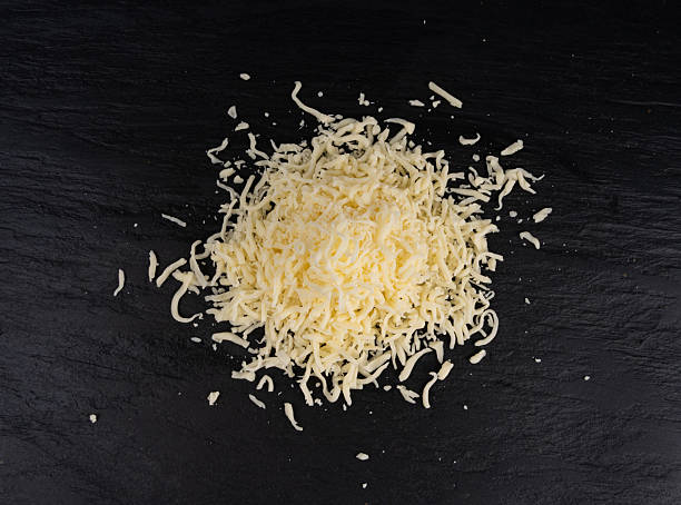 istock Grated mozzarella cheese on black background. Shredded mozarella texture 2247208991