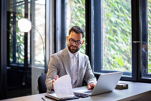 istock Businessman working on laptop in modern office 2247211720
