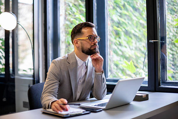istock Thoughtful businessman planning strategy at modern office desk 2247211726