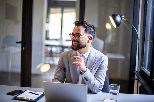 istock Happy young businessman working on laptop in modern office 2247211842