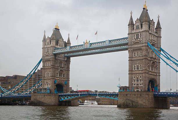 Young man is holding his mobile phone up above his head and capturing that perfect time of the day, Tower Bridge, London