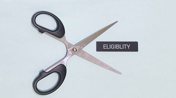 istock Dramatic cut in eligibility requirements shown with scissors, symbolizing restrictions and policy changes 2247223987