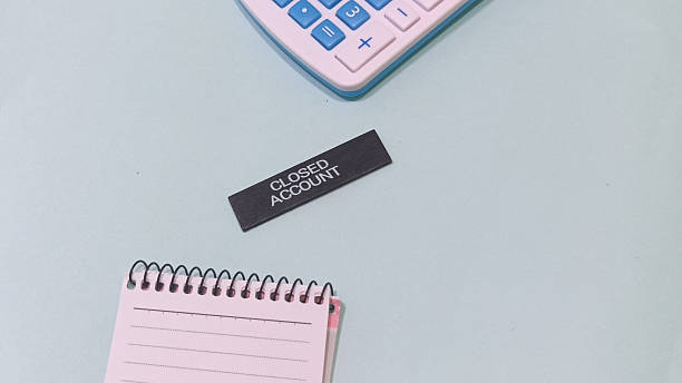 Conceptual shot of closing accounts and financial planning with calculator and notebook. Illustrates debt management and economic concepts.