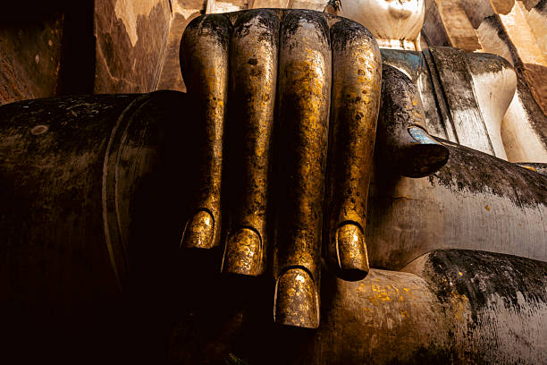 Monumental Buddha image Phra Atchana in subduing mara posture at Wat Sri Chum temple Sukhothai Historical Park, ancient stuccoed brick sculpture, thailand cultural heritage landmark