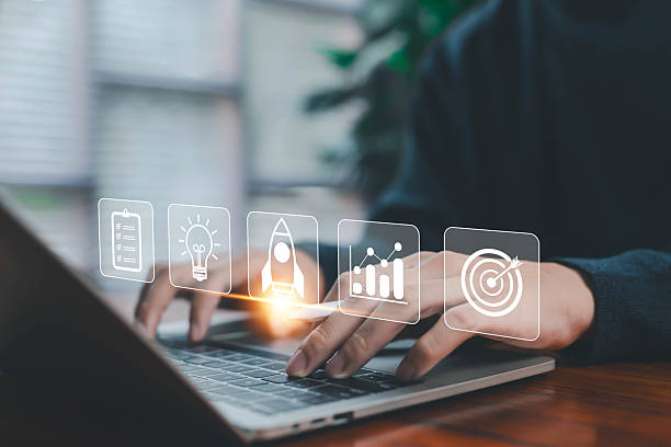 istock A person working on a laptop with floating business icons including checklist, idea, rocket, analytics, target, symbolizing startup planning, innovation, growth strategy, digital business development. 2247226291
