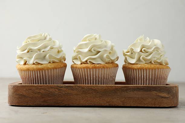 istock Tasty cupcakes with vanilla cream on light grey table, closeup 2247229027