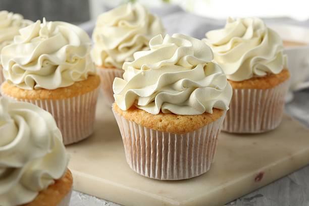 istock Tasty cupcakes with vanilla cream on grey table, closeup 2247229052