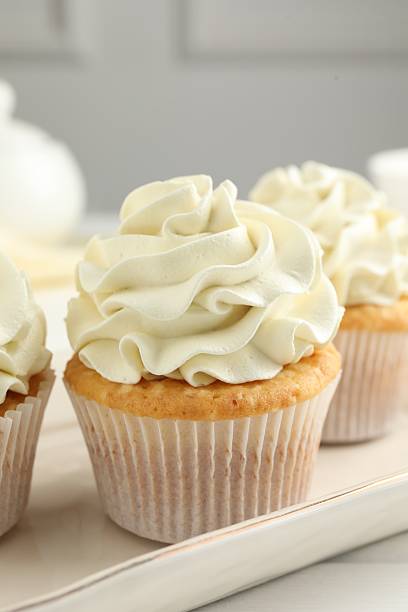istock Tasty cupcakes with vanilla cream on white wooden table, closeup 2247229078