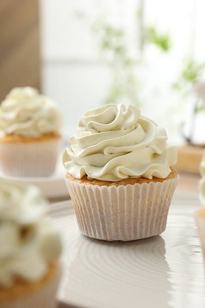 istock Tasty cupcakes with vanilla cream on table, closeup 2247229131