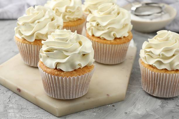 istock Tasty cupcakes with vanilla cream on grey table, closeup 2247229132