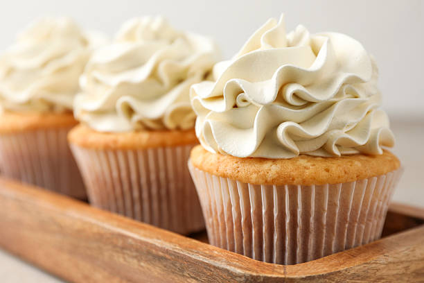 istock Tasty cupcakes with vanilla cream on table, closeup 2247229152