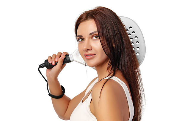 Woman holding a frying spatula and smiling in a bright kitchen setting