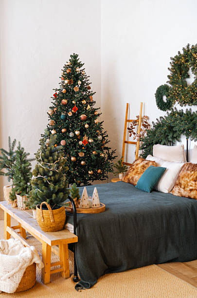 istock Cozy bedroom with decorated Christmas tree and winter wreath overhead 2247233856
