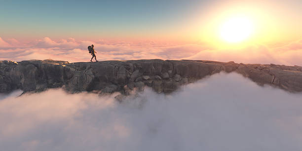 istock Hiker standing on rocky peak above clouds during vibrant sunrise 2247234266