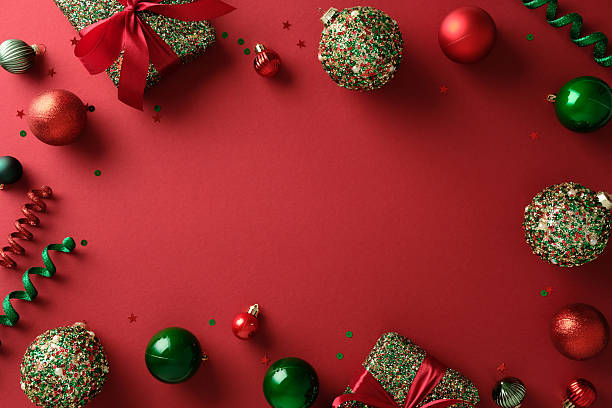 istock Christmas frame border with sparkling red and green ornaments, gift boxes, confetti on vibrant red background. 2247236734