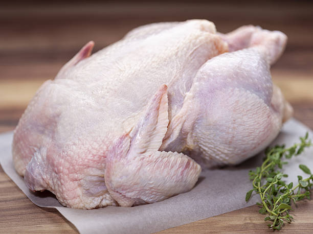 istock Raw Whole Chicken with Fresh Herbs on Wooden Surface. 2247238674
